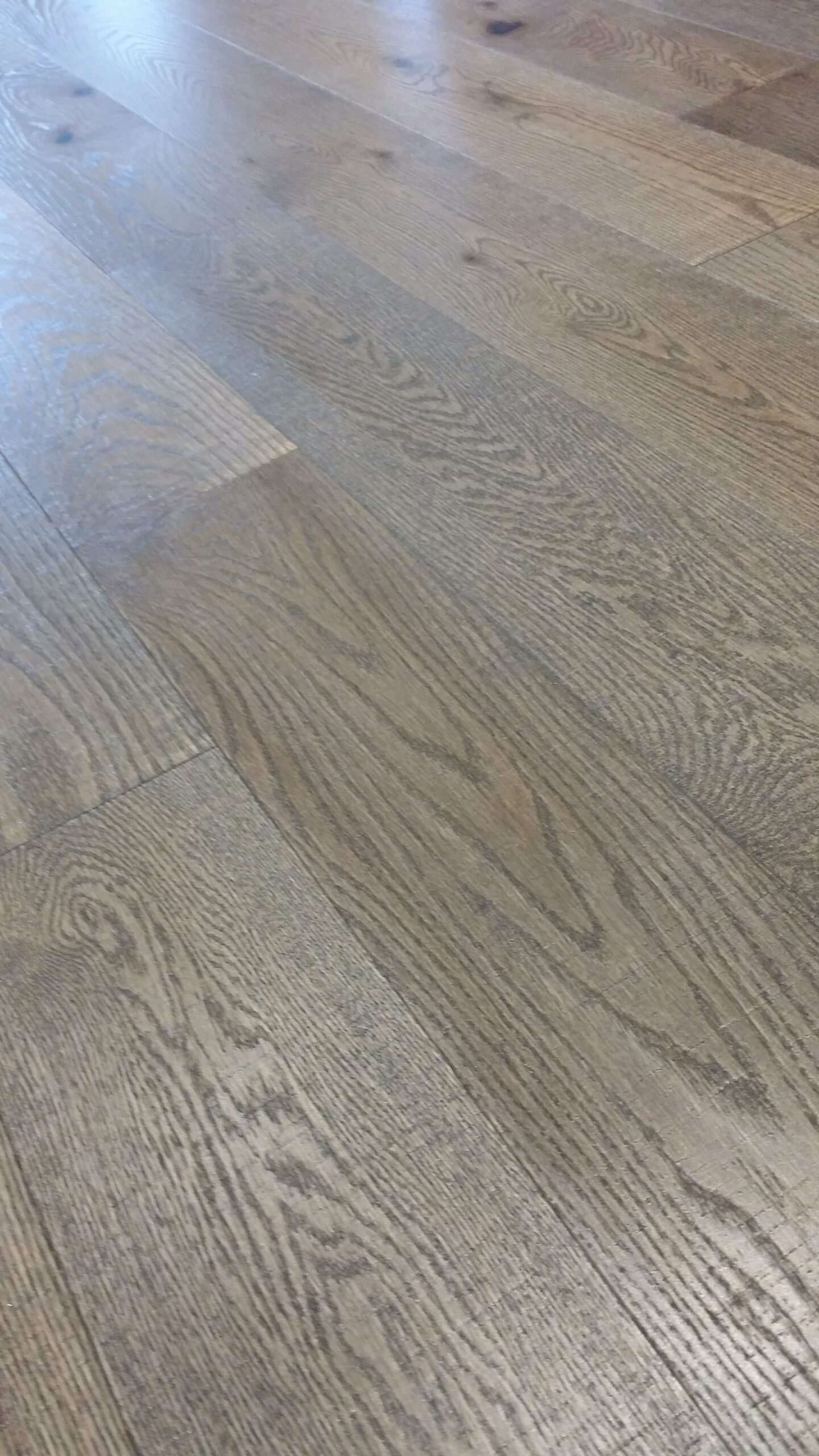 Bodenbelag in grauer Holzoptik, wie er als Vinyl oder Laminat verlegt wird