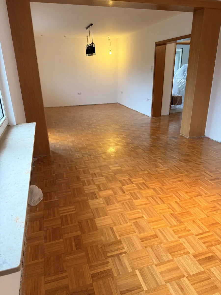 Vorher: Wohnzimmer mit altem Parkett, dunkel und glänzend vom Altlack